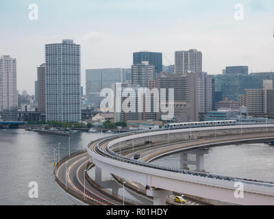 Moderne Autobahn mit Pkw und Bahn führt zu einer Brücke. Rainbow Bridge, Tokio, Japan. Stockfoto