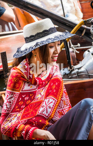 Damnoen Saduak, Thailand - 8. Oktober 2018: Chinesische Mädchen Tourist in hat am schwimmenden Markt. Der Markt ist ein sehr populär Reiseziel. Stockfoto