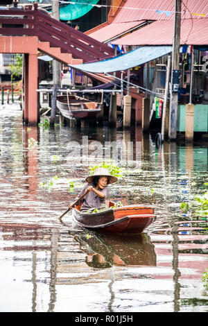 Damnoen Saduak, Thailand - 8. Oktober 2018: eine Frau Paddel ihr Boot am Kanal entlang. Der schwimmende Markt hier ist ein sehr beliebtes Touristenziel. Stockfoto