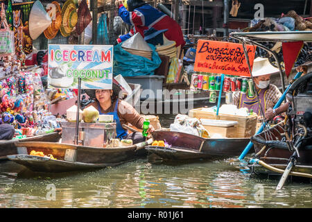 Damnoen Saduak, Thailand - 8. Oktober 2018: Anbieter in Boote Verkauf von Eis und gegrilltem Fleisch auf dem schwimmenden Markt. Der Markt ist ein sehr populär Stockfoto