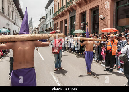 Quito, Ecuador - 22. April 2011: Zwei unbekannte Maenner tragen ein Protokoll im Rücken als in einem religiösen procesion penitance Stockfoto