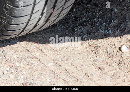 Spuren von den Rädern der Autos auf der Straße vom Sand, Nahaufnahme auf der Straße Stockfoto