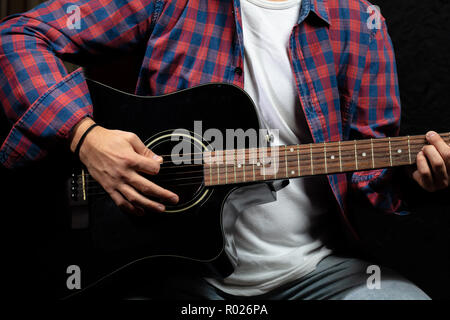 Junger Mann mit Gitarre, Ansicht schließen, dunklen Hintergrund Stockfoto
