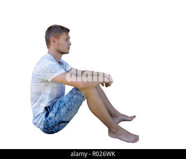Seite in voller Länge Porträt einer beiläufigen junge Mann sitzt auf dem Boden und Meditieren isoliert auf weißem Hintergrund. Stockfoto