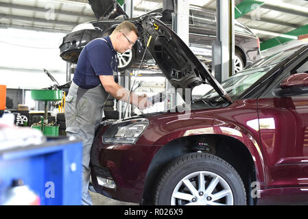 Kfz-Mechaniker in einer Werkstatt - Motor Reparatur und Diagnose an einem Fahrzeug Stockfoto