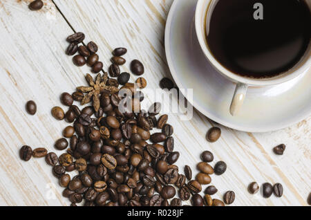Tasse Kaffee und Kaffeebohnen auf weißem Holz- Hintergrund. Stockfoto