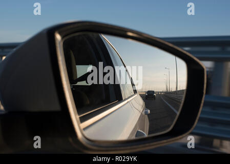 Abends Straße mit Autos im Rückspiegel Stockfoto