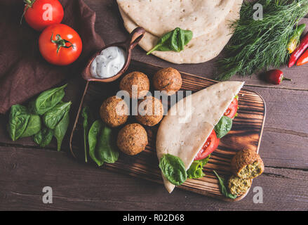Falafel, frisches Gemüse, Soße und pita Brot auf hölzernen Tisch Stockfoto