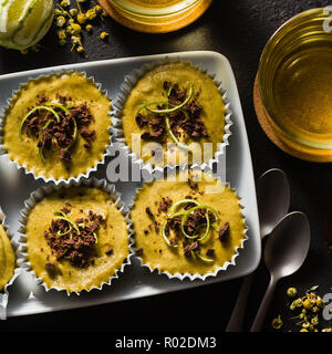 Raw vegan Cupcakes von Pistazien, Cashewkerne und Termine mit Schokolade und Kalk. und Kamille Tee im Glas Tassen. gesunden Urlaub Dessert. Gute gesunde Stockfoto