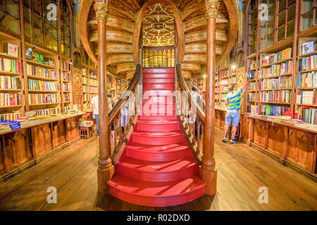 Oporto, Portugal - 13. August 2017: Große Holztreppe mit roten Stufen innerhalb der Bibliothek Lello und Irmao im historischen Zentrum von Porto, berühmt für Harry Potter Film. Horizontale erschossen. Stockfoto