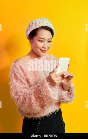 Gruselige Mädchen mit trägt, weiche Fell holding Smartphone. Stockfoto