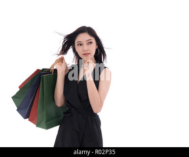 Junge Frau denken und Holding Shopping Bag auf weißem Hintergrund Stockfoto