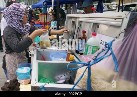 Kota Kinabalu in Sabah Malaysia - Jun 9, 2018: Nicht identifizierte Muslime essen Anbieter verkaufen Gericht namens Bakso bei Kota Kinabalu Straße bazart. Die berühmte Gericht Stockfoto