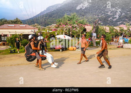 Fethiye, Marmaris/Türkei - 19. August 2018: Tandem Paraglider landen auf Belcekiz Beach in Ölüdeniz. Stockfoto