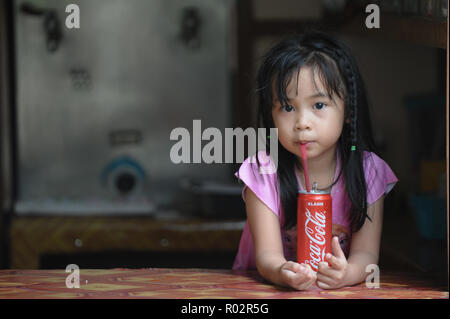 Kiulu Sabah Malaysia - Dec 24, 2017: junge Asiatin kohlensäurehaltige Getränke in Dosen Coca-Cola auf Straßen Restaurant in Kiulu Sabah. Stockfoto