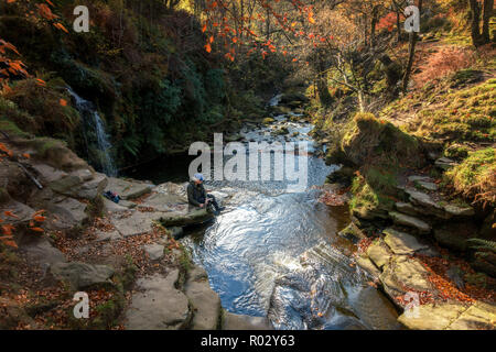 Senior Fotograf mit einer langen Belichtungszeit Foto von Wasserfällen im Herbst mit Stativ, Lumb Loch fällt, in der Nähe von Halifax und Hardcastle Crags Stockfoto