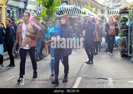 LONDON, ENGLAND - Oktober 12, 2018 Gruppe junger Freunde wandern in berühmten Brick Lane in London. Multikulturelle Menschen mit gemischten Rassen tragen Farbe Stockfoto