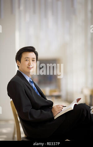 Porträt einer Mitte - Erwachsene Lehrer lesen in einer Studie Halle einer Schule. Stockfoto