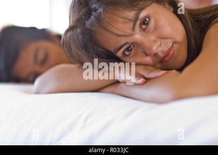 Porträt eines jungen erwachsenen Mädchen liegen auf einem Bett. Stockfoto