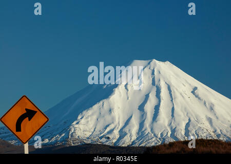Ecke Zeichen auf Wüste Straße und Mt Ngauruhoe, Tongariro National Park, Central Plateau, North Island, Neuseeland Stockfoto