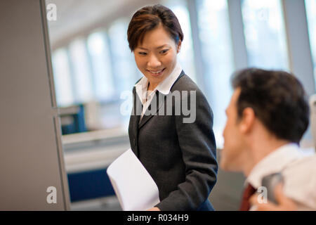 Lächeln, Geschäftsfrau, die ihr Kollege ein Dokument. Stockfoto