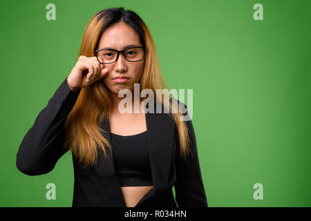 Portrait von jungen asiatischen Geschäftsfrau vor grünem Hintergrund Stockfoto