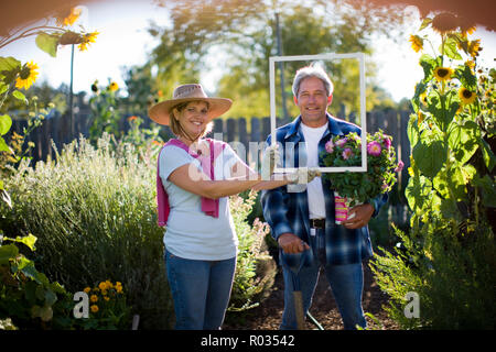 Porträt eines lächelnden nach paar stehen in Ihren Garten. Stockfoto