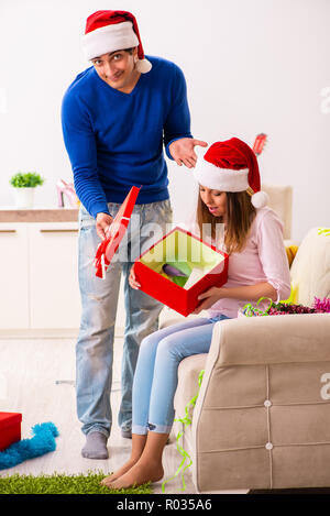 Junges Paar Weihnachten zu Hause feiern. Stockfoto