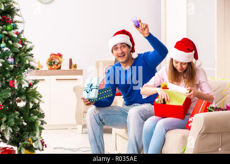 Junges Paar Weihnachten zu Hause feiern. Stockfoto
