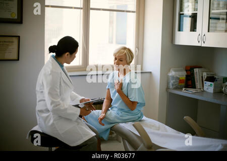 Ärztin Consulting mit einem Patienten nach einer ärztlichen Untersuchung in ihrem Büro. Stockfoto