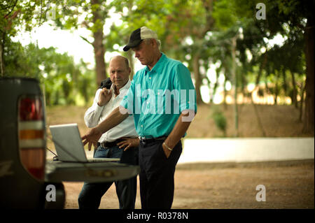 Bauer zeigt etwas auf einem Laptop zu einem Geschäftsmann. Stockfoto