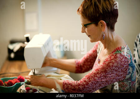 Frau mittleren Alters mit einer Nähmaschine. Stockfoto