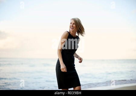 Happy Geschäftsfrau zu Fuß am Strand. Stockfoto