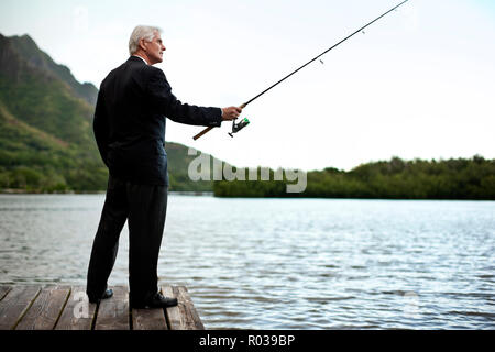 Formal ausgereift Geschäftsmann zum Fischen auf den See gekleidet. Stockfoto