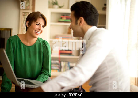 Zwei Kollegen sprechen beim Gehen hinunter eine städtische Straße. Stockfoto