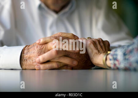 Ältere Frau legt eine tröstende Hand auf dem Arm ihres Mannes. Stockfoto