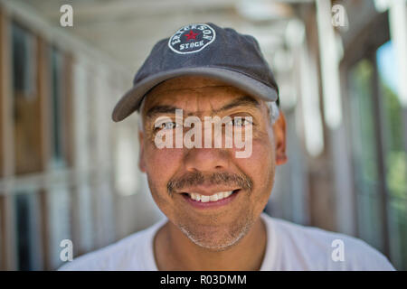Builder stehen auf einer Trittleiter aus Holz. Stockfoto