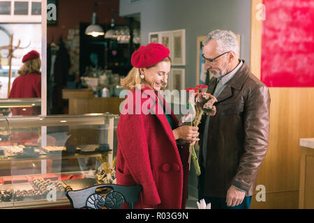 Liebevolle pflege Mann präsentiert schöne Blumen seine elegante schöne Dame Stockfoto