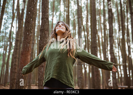 Schöne junge Frau Wanderer genießen und entspannen in Holz ihren Arm angehoben Stockfoto