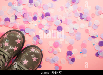 Die niedlichen Kind grün Schuhe mit Stern Print auf rosa Hintergrund mit bunten Konfetti. Stockfoto