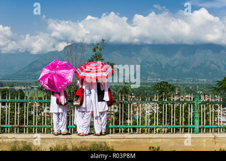 Drei Schule Mädchen, tragen weiße Tücher und mit Sonnenschirmen, Blick auf die Stadt Srinagar aus der Sicht Stockfoto