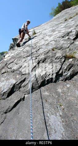 Bergführer Kletterer auf eine Platte aus Kalkstein Klettersteig in den Alpen der Schweiz an einem schönen Tag Stockfoto