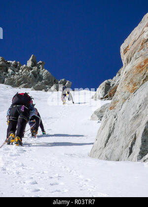 Drei Bergsteiger auf einem steilen north face nach oben eine schmale Rinne Stockfoto