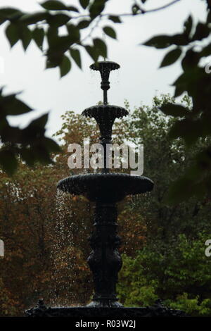 Dreistufige Springbrunnen gegen Wald Hintergrund eingerahmt Stockfoto