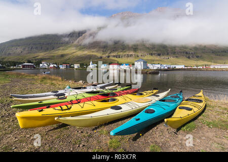 Seydisfjördur, ISLAND - AUGUST 2018: waterfront Blick auf die Fachwerkhäuser in der Altstadt mit Kunststoff Kajaks auf den Vordergrund. Stockfoto