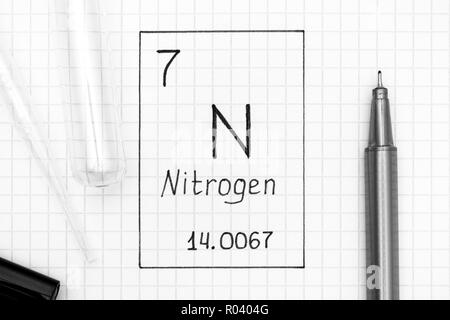 Das Periodensystem der Elemente. Handschrift chemische Element Stickstoff N mit schwarzem Stift, Reagenzglas und Pipette. Close-up. Stockfoto