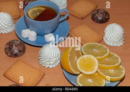 Zitrone, Eibisch, Lebkuchen und Plätzchen mit einer Tasse Tee auf einem hölzernen Hintergrund Stockfoto