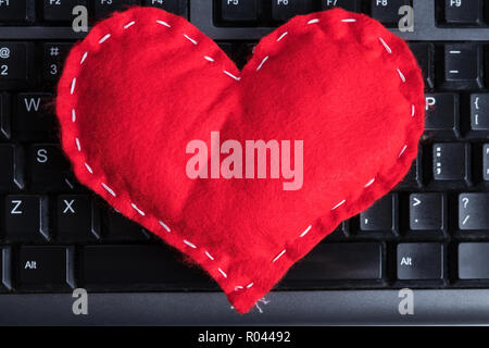 Red hausgemachte Herz auf einer Computertastatur am Valentinstag. Stockfoto