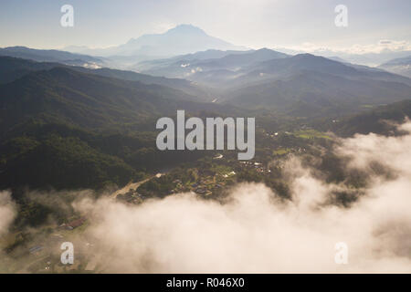 Ein Luftbild von misty Valley in Kiulu Sabah Malaysia Borneo mit sanften Hügeln Richtung Mount Kinabalu im fernen Hintergrund. Stockfoto
