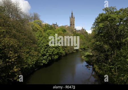 Der Glockenturm und die Turmspitze der Glasgow University Blick nach unten über eine überdachung der Bäume und den Fluss Kelvin in der Kelvingrove Park im West End von Glasgow. Stockfoto